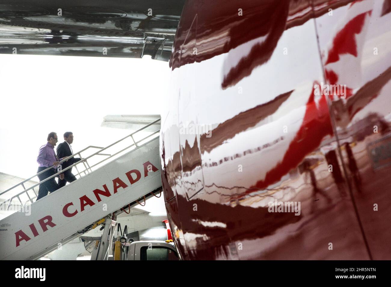 Guests climb aboard a plane in an Air Canada hanger at Toronto's