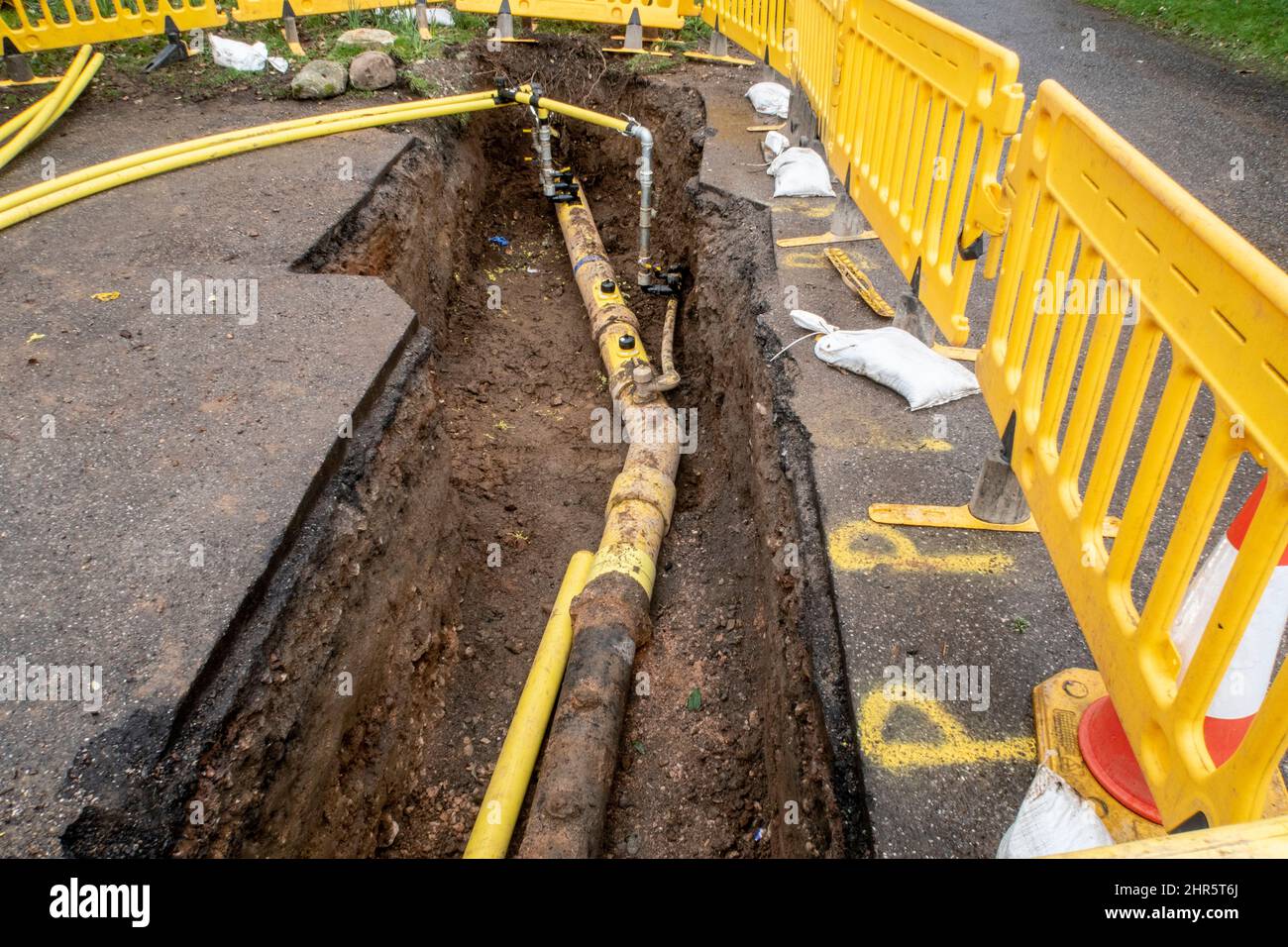 Gas main pipe uncovered during pipework replacement in Sidmouth, Devon, UK. Roadworks, hole in the ground, gas main. Stock Photo