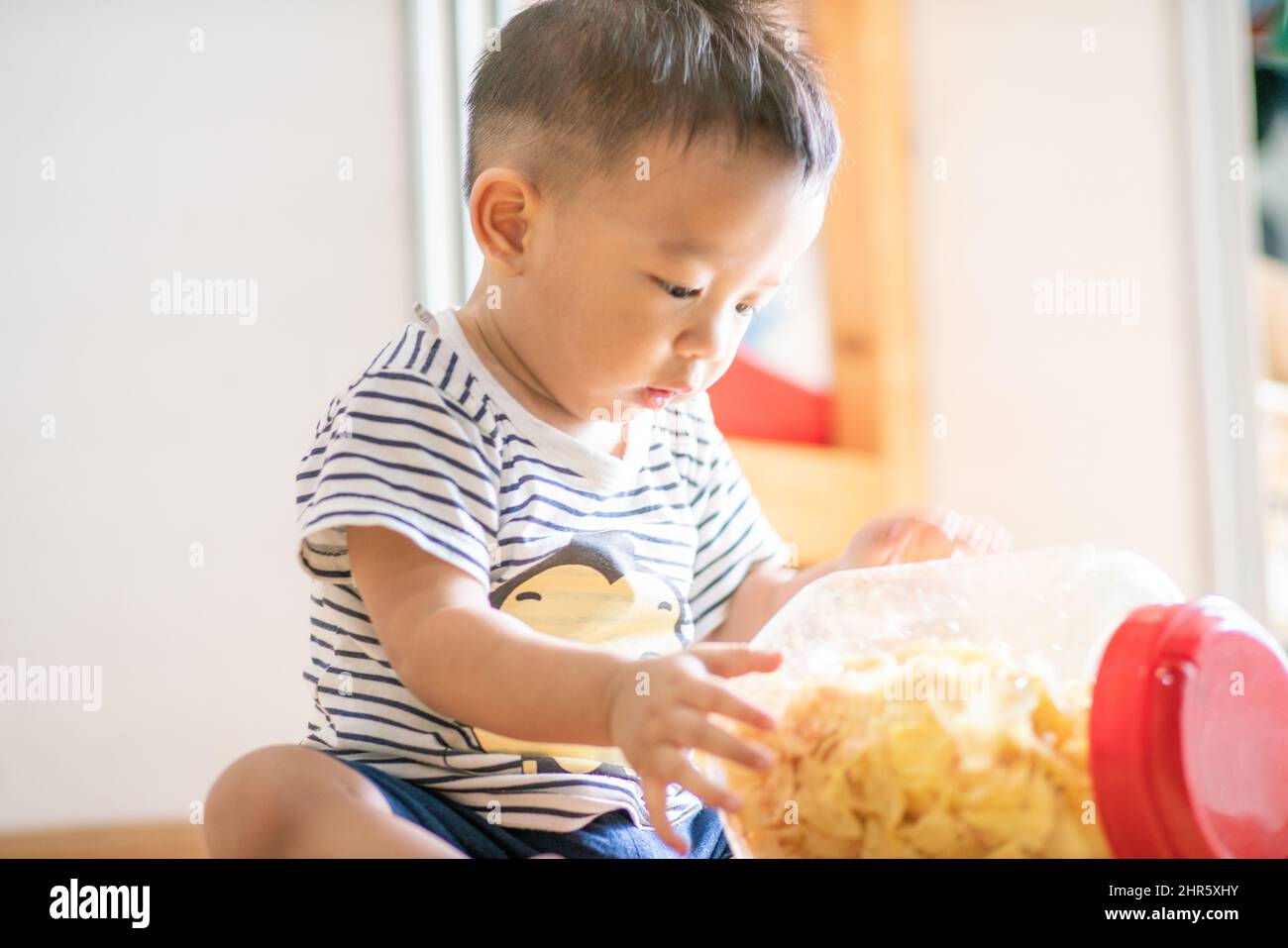 Adorable toddler baby boy with snack food in home, Funny boy education Stock Photo