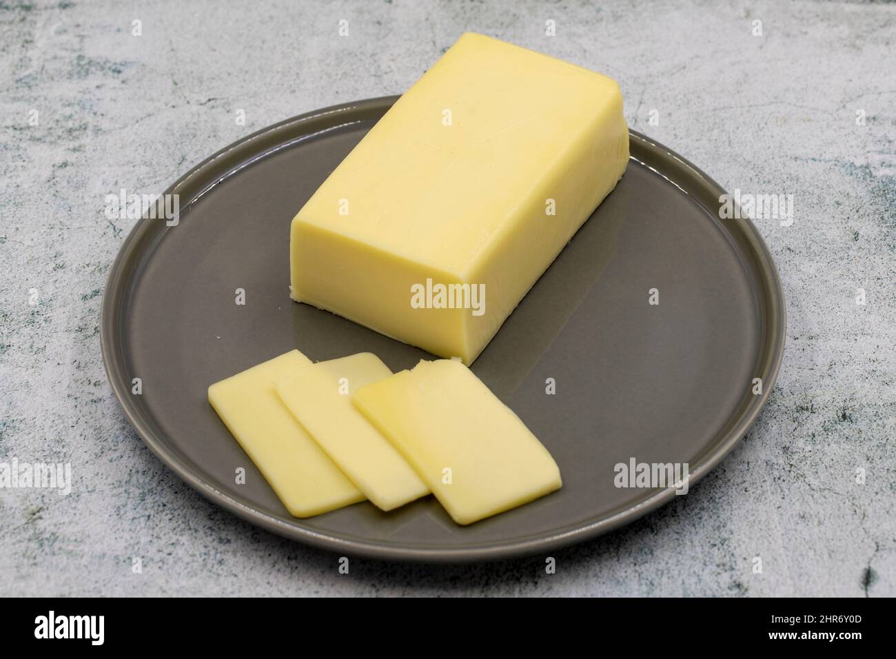 Kashar cheese or kashkaval cheese on stone background. Sliced Cheddar Cheese Stock Photo