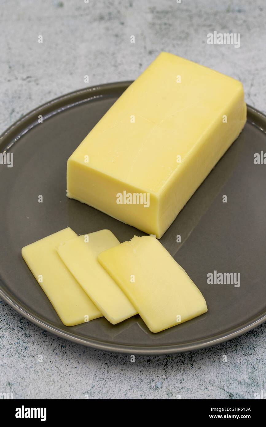 Kashar cheese or kashkaval cheese on stone background. Sliced Cheddar Cheese Stock Photo