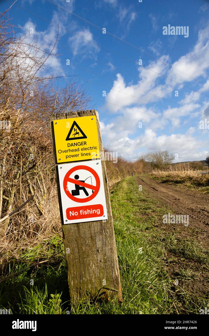 Overhead power lines warning to fishermen on the Grantham Canal towpath, Woolsthorpe by Belvoir, Lincolnshire. Danger, no fishing Stock Photo