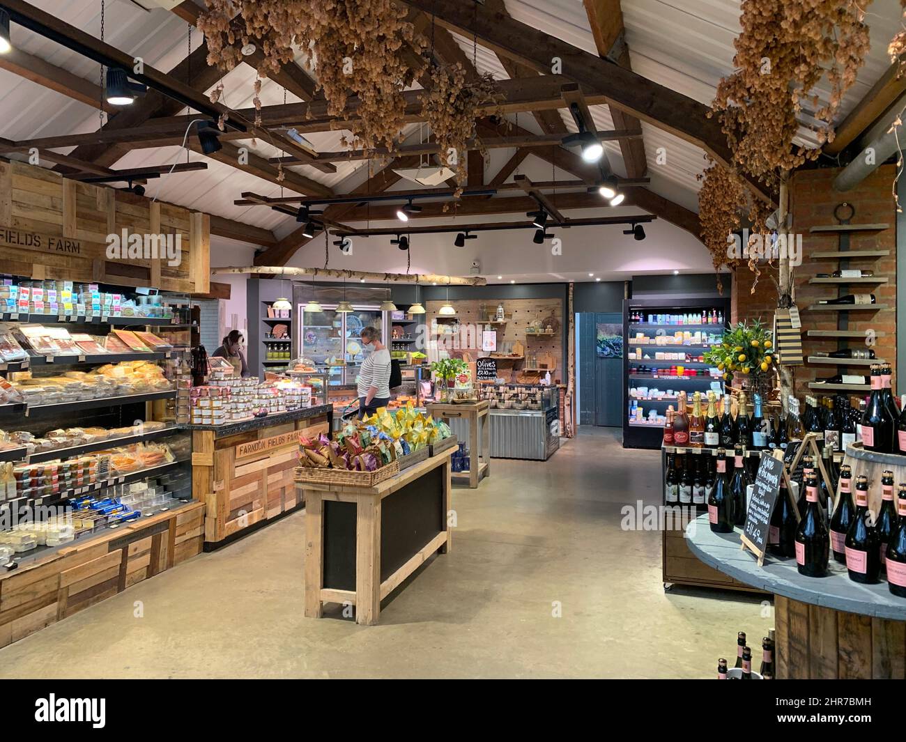 Farndon Fields farm shop Market Harborough Leicestershire England barn Garden Centre hanging baskets shop people person wine selling sell Stock Photo