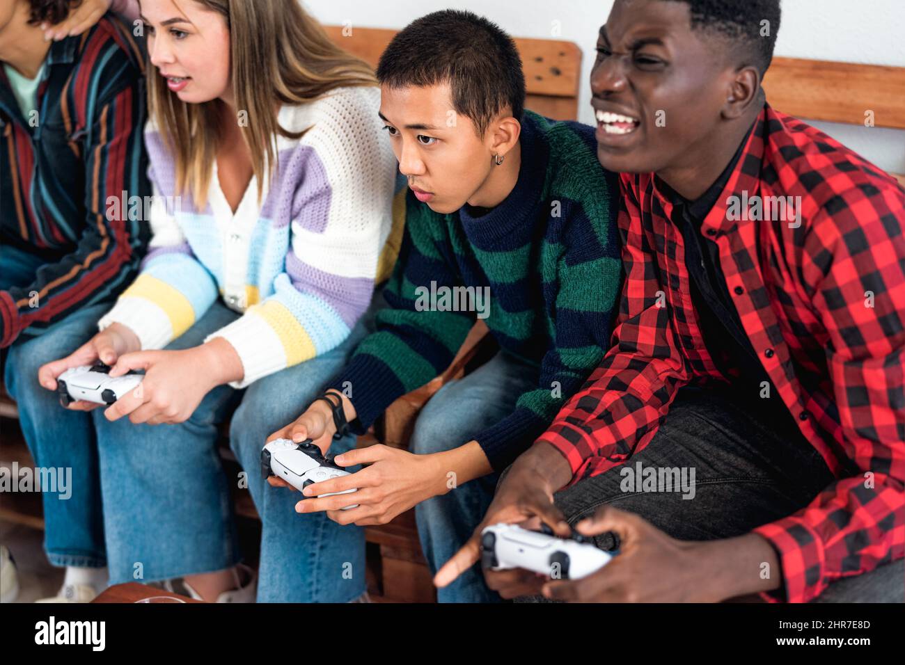 Young Multiracial Teenagers Playing Online Video Game Console At Home 