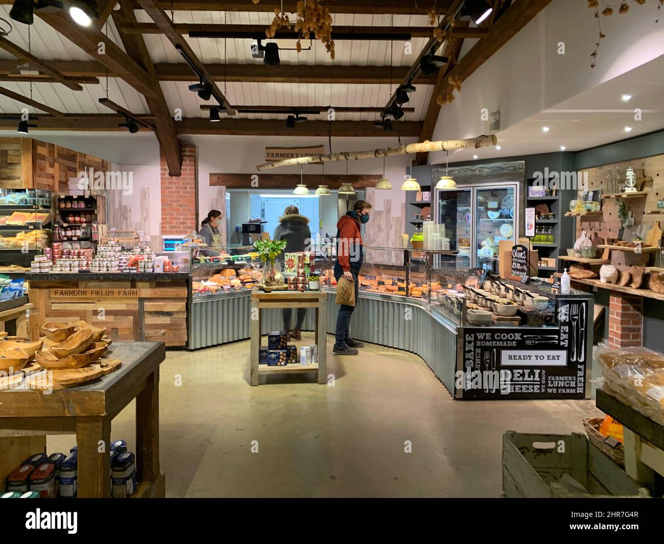 Farndon Fields farm shop Market Harborough Leicestershire England counter mask pies pie hat bag customers people food buy buying inside wood beams Stock Photo