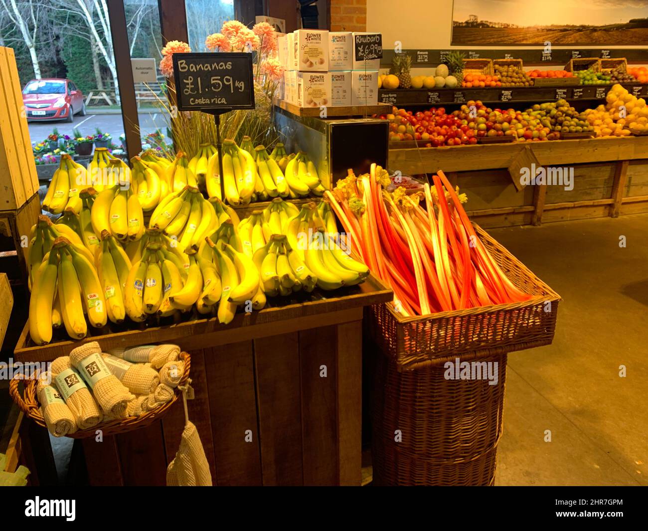 Bananas and rhubarb in Farndon Fields farm shop Market Harborough Leicestershire England fresh sweetcorn basket sell for sale price sign signs tray Stock Photo