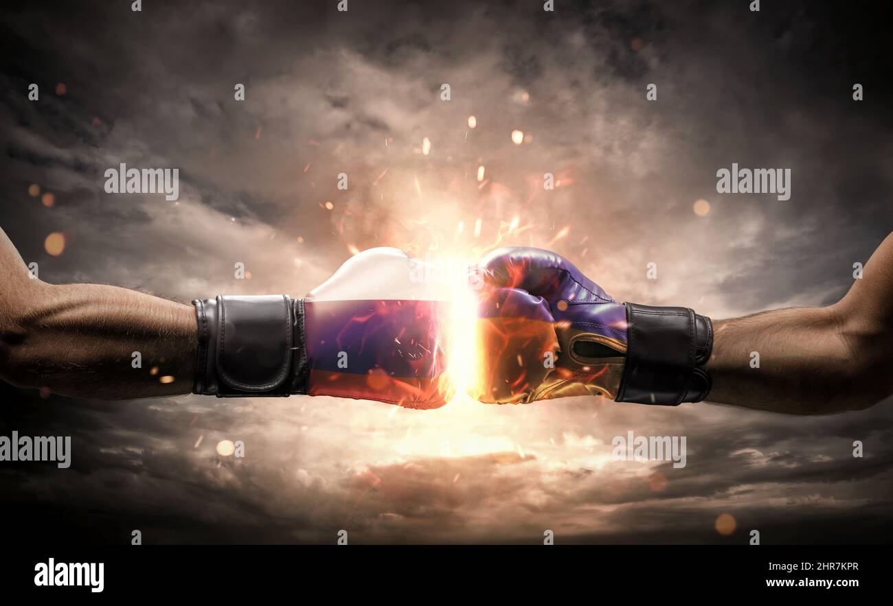 Conflict, war concept. Close up of two fists hitting each other over dramatic sky Stock Photo