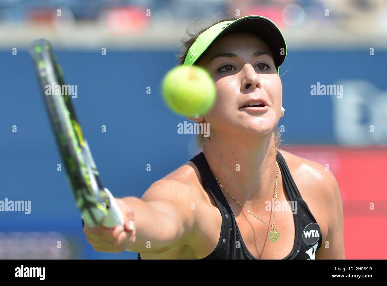 Belinda Bencic, of Switzerland, hits a return to Simona Halep, of