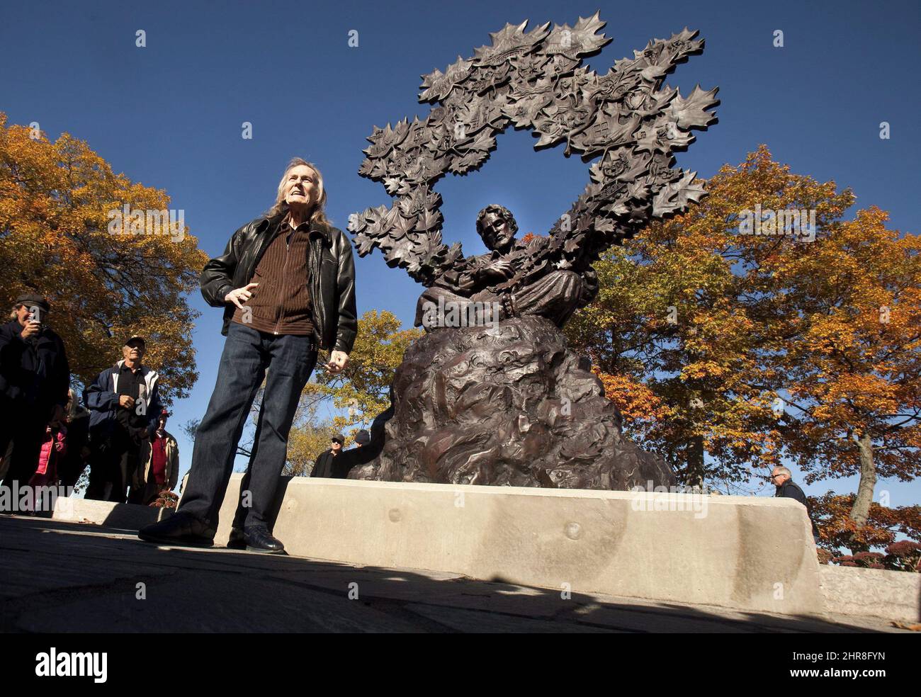 Gordon Lightfoot poses as attends a ceremony unveiling a bronze statue