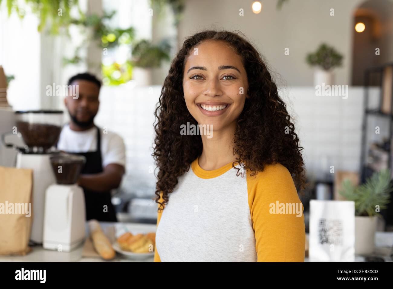Portrait of smiling african american woman standing at cafe counter ...