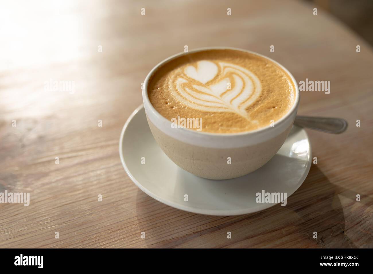 https://c8.alamy.com/comp/2HR8XG0/high-angle-close-up-of-fresh-cappuccino-with-froth-art-served-in-mug-on-table-at-cafe-2HR8XG0.jpg