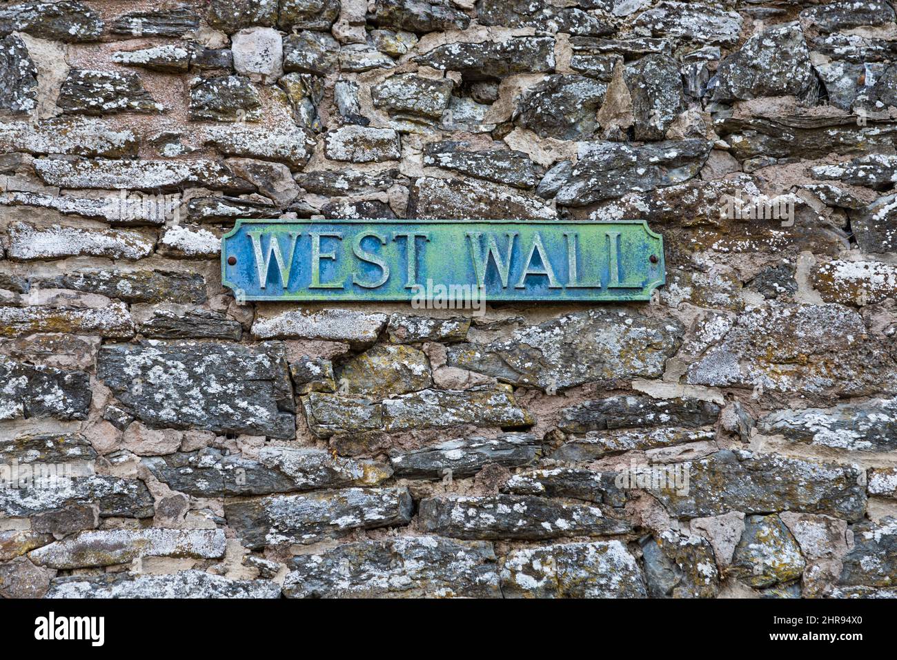 West Wall cast iron street name sign on old stone wall Stock Photo Alamy