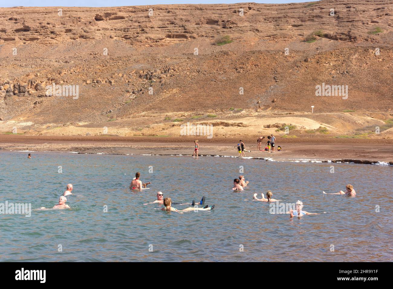Tourists floating in salt evaporation ponds in crater lake, Pedra de Lume, Sal (IIha do Sal), República de Cabo (Cape Verde) Stock Photo