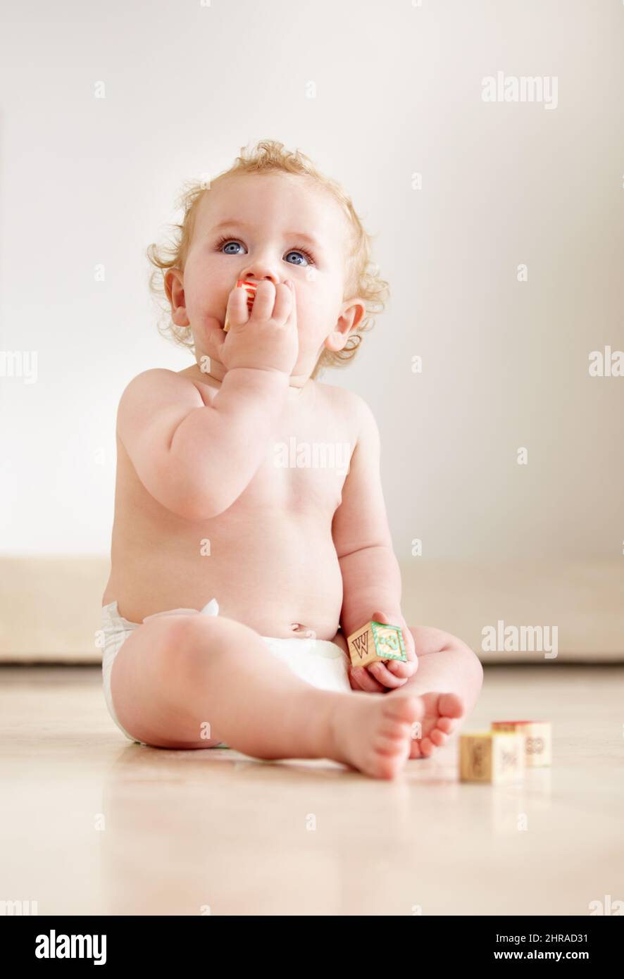 Filled with curiousity and wonder. Cute baby boy looking up curiously while sitting on the floor. Stock Photo