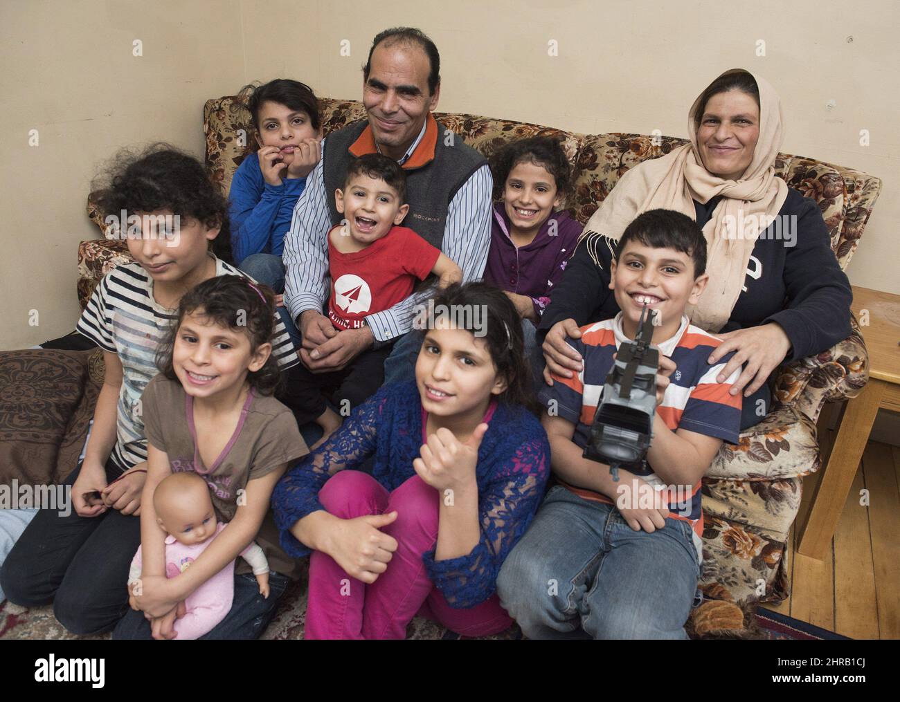 Abdel Al Shaikh, 10, front right, sits with his family in their home in Fredericton, N.B., Saturday, January 21, 2017. Abdel had a photo taken of him during Prime Minister Justin Trudeau's recent visit to Fredericton. In the photo he is holding his face because his brother Omar, in red, wouldnÃ¢Â€Â™t stop bothering him which was keeping him from hearing what Trudeau was saying. From left in front are: Najwa Al Shaikh, 11; Mariam Al Shaikh, 5; Wesal Al Shaikh, 12; Abdel Al Shaikh, 10, back row: Rahaf Al Shaikh, 13; Hassan Al Shaikh, Dad; Omar Al Shaikh, 2; Khadija Al Shaikh, 10; and Radiya Al S Stock Photo