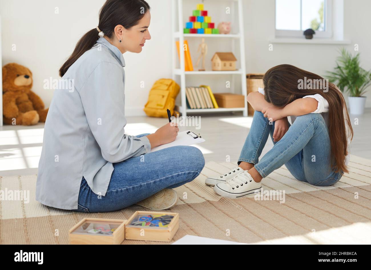Female school psychologist talks to teenage girl about child's problems with peers. Stock Photo