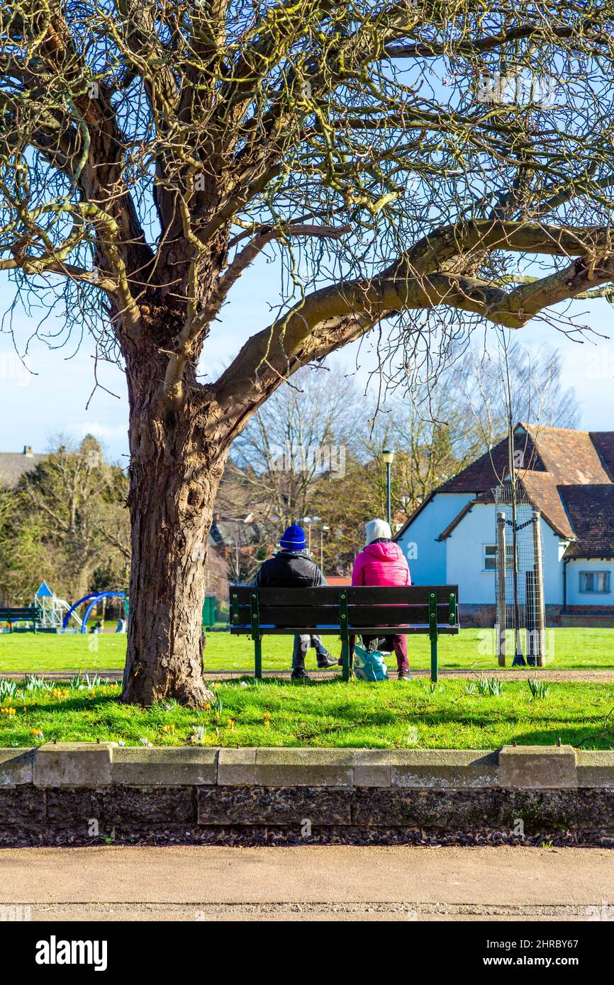 Two people sitting on a park bench talking at Bancroft Splash Park