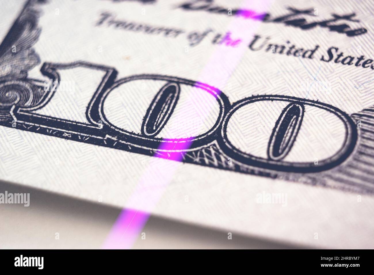 Checking dollar banknotes in a UV light. Counterfeit money concept. Fragment of the Obverse side of 100 one hundred dollars bill banknote. New sample Stock Photo
