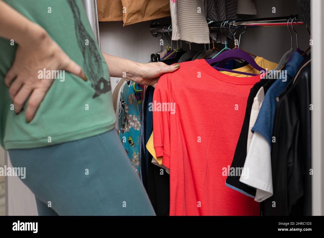 woman chooses red t-shirt in wardrobe at home. High quality photo Stock Photo