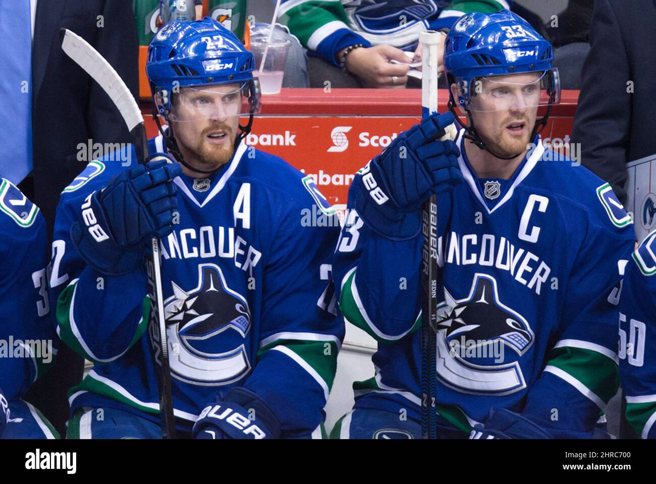 Vancouver Canucks Daniel Sedin, left, and his twin brother Henrik Sedin sit on the bench during the third period of an NHL hockey game against the Los Angeles Kings in Vancouver on
