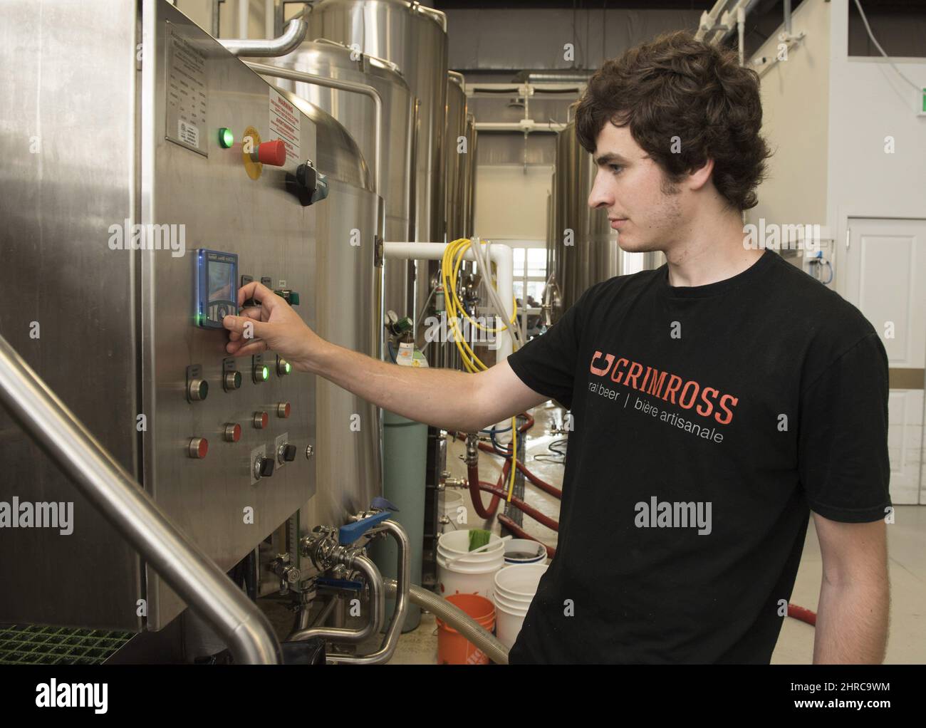 Callum Stewart, brewery operations manager at Grimross Craft Brewing, makes adjustments to their equipment at their business in Fredericton, N.B., on Friday, June 16, 2017. The craft brewing industry is booming in Fredericton and officials in New Brunswick's capital are hoping tourists will want to taste what the city has on tap. THE CANADIAN PRESS/Stephen MacGillivray Stock Photo