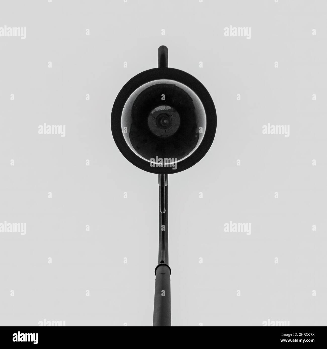 Minimalist photo of a street lamp from underneath against a solid