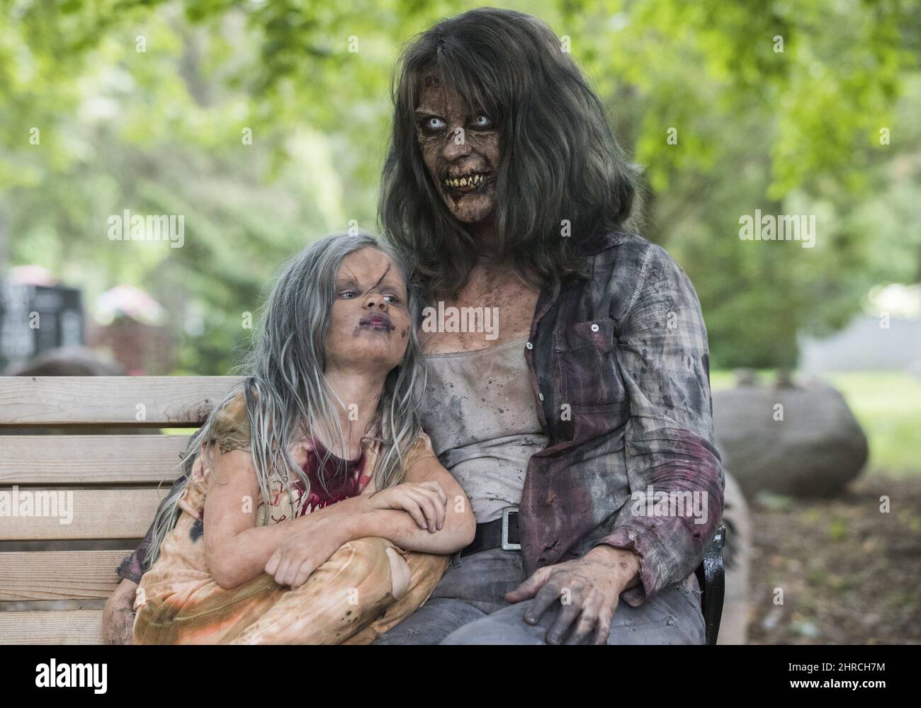 Leanne MacRae and her daughter Miranda sit on a bench after attending a memorial service dressed up as zombies to pay tribute to zombie film director George Romero who passed away at