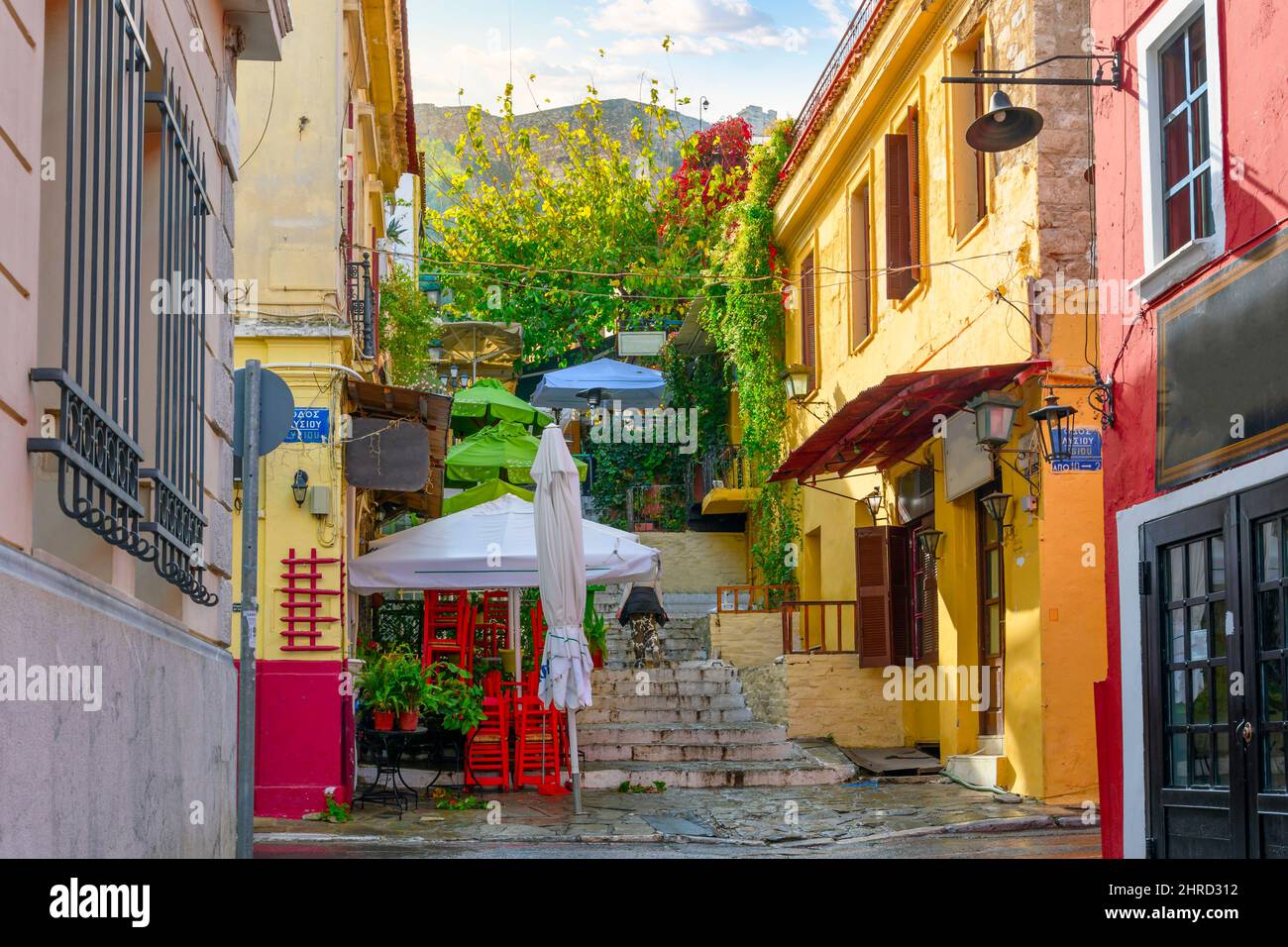A colorful hillside alley in the Plaka district of Athens, Greece, with cafes and shops at the base of the ancient Acropolis. Stock Photo