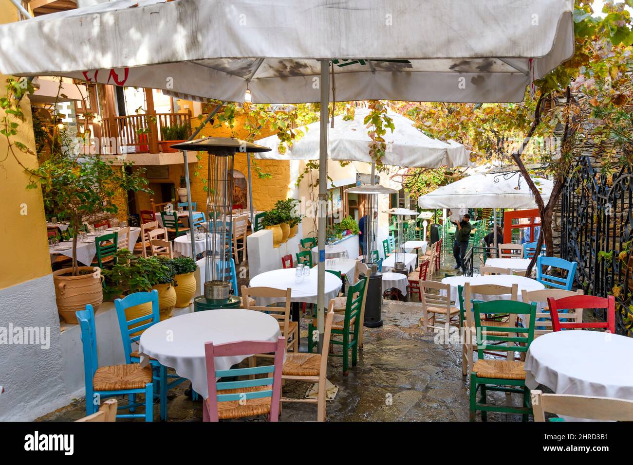 A colorful hillside alley in the Plaka district of Athens, Greece, with a cafe at the base of the ancient Acropolis. Stock Photo