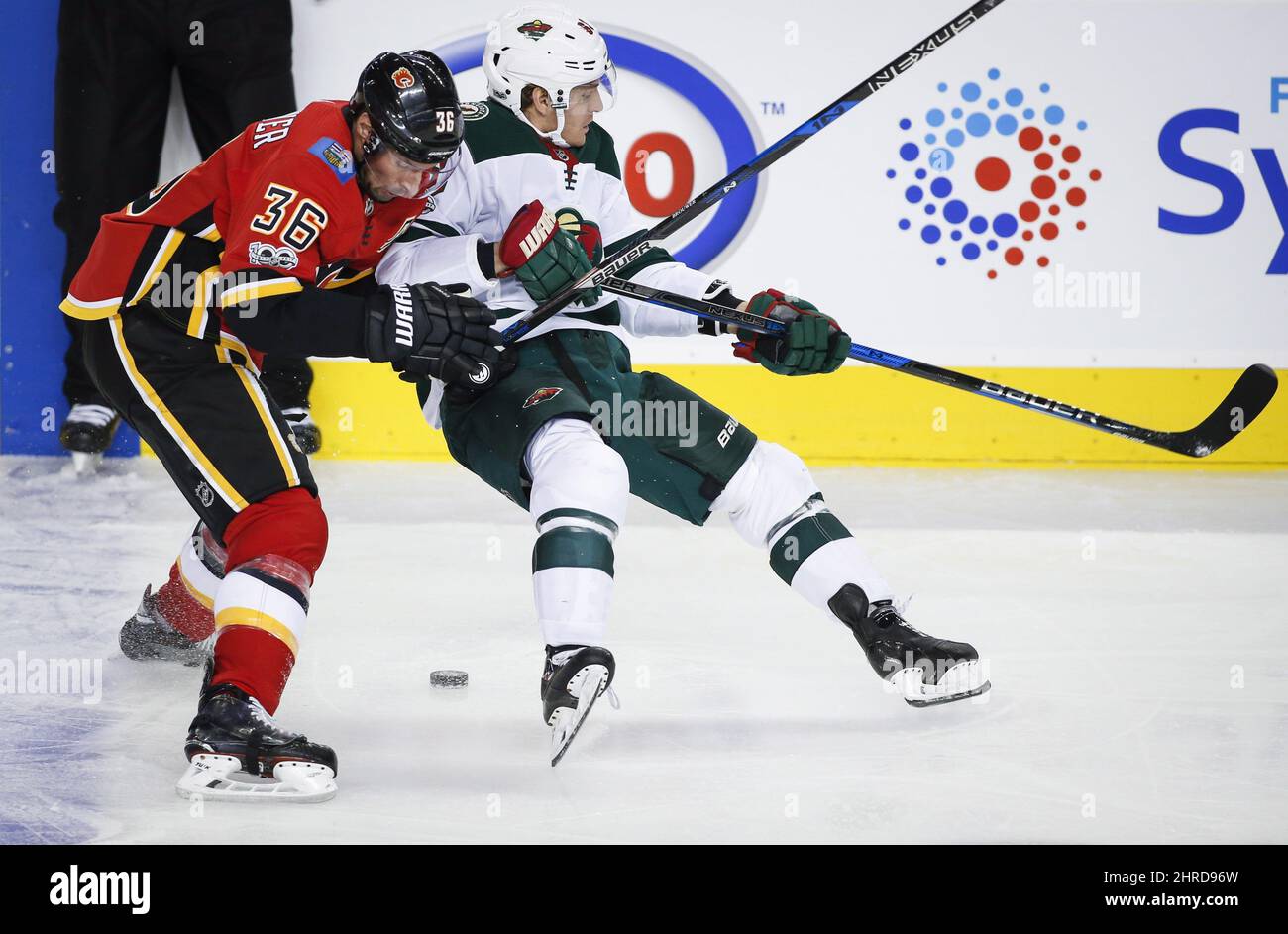 Minnesota Wild's Tyler Ennis, right, is checked by Calgary Flames' Troy