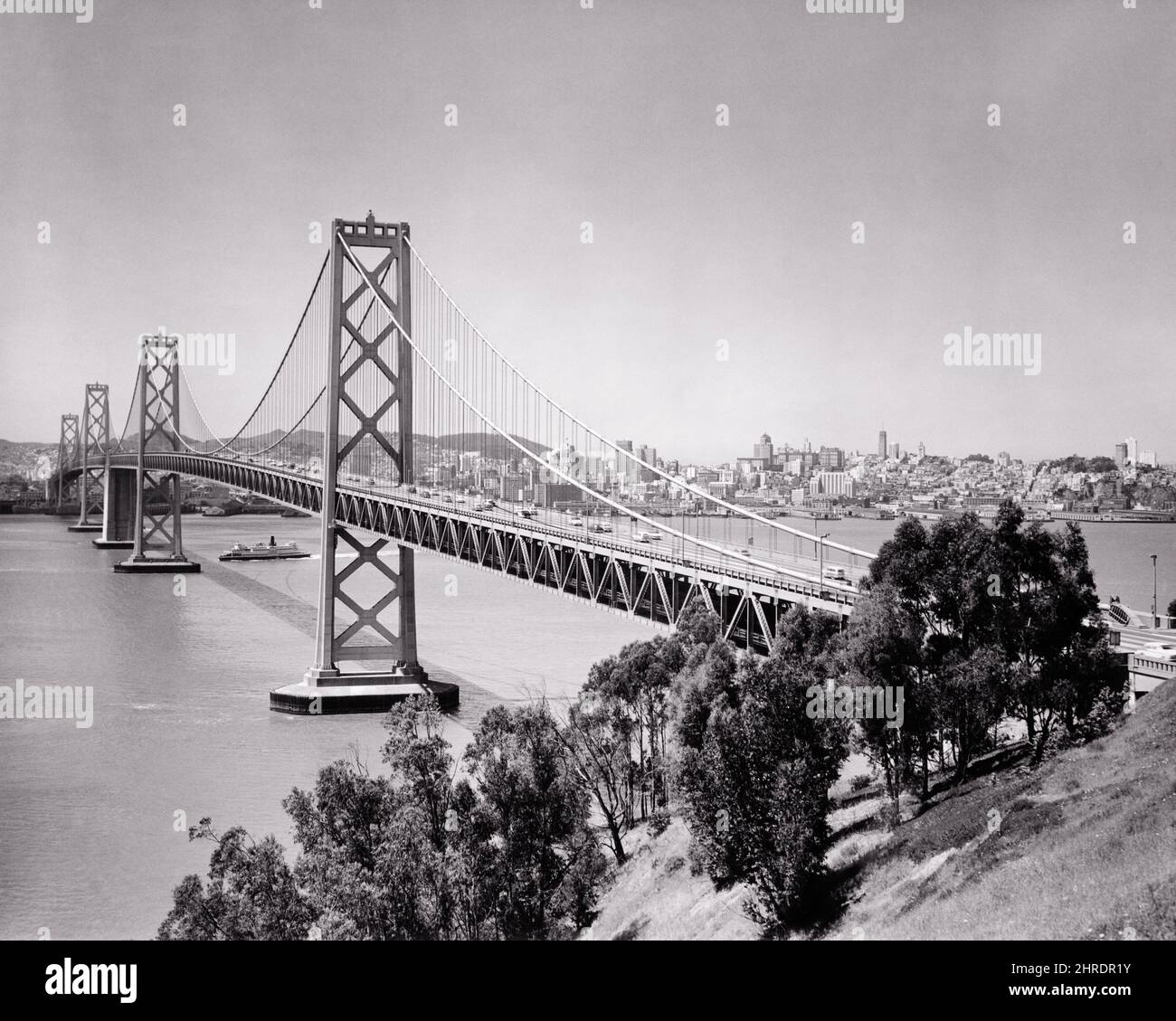 1940s 1950s WESTERN SPAN OF THE OAKLAND BAY BRIDGE LOOKING TOWARDS SF AS SEEN FROM YERBA BUENA ISLAND SAN FRANCISCO CA USA - b4827 HAR001 HARS CONCEPTUAL 1936 CITIES OAKLAND BUENA OAKLAND BAY BRIDGE SAN FRANCISCO BUILT SPAN BLACK AND WHITE BRIDGES CABLE DESIGNED HAR001 OLD FASHIONED SUSPENSION Stock Photo