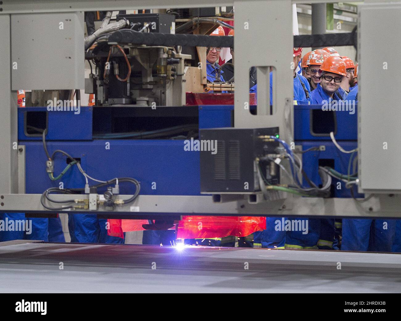 Irving Shipbuilding workers look on at a ceremony as the first piece of