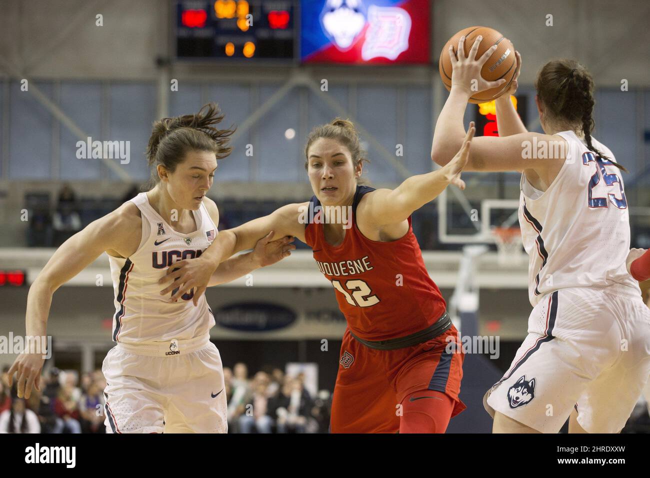 Duquesne Lady Dukes' Anie-Pier Samson, centre, of Saint-Bruno, Que., offers  defence as she takes on Connecticut Huskies' Molly Bent and teammate Kyla  Irwin, right, during second half women's basketball action in Toronto