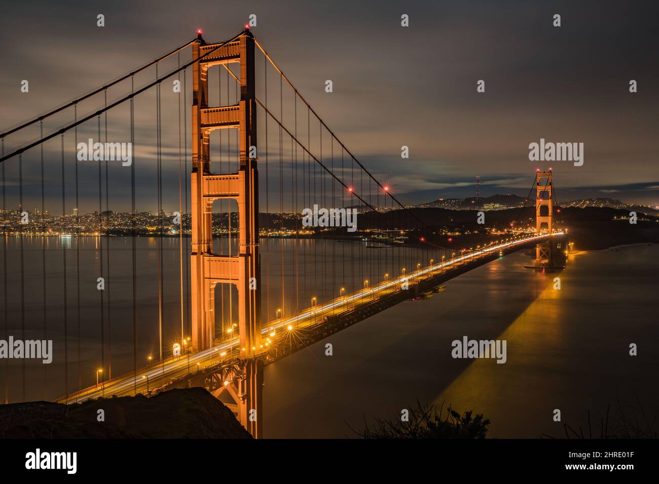 Beautifully illuminated bridge in the evening with the cloudy sky in ...