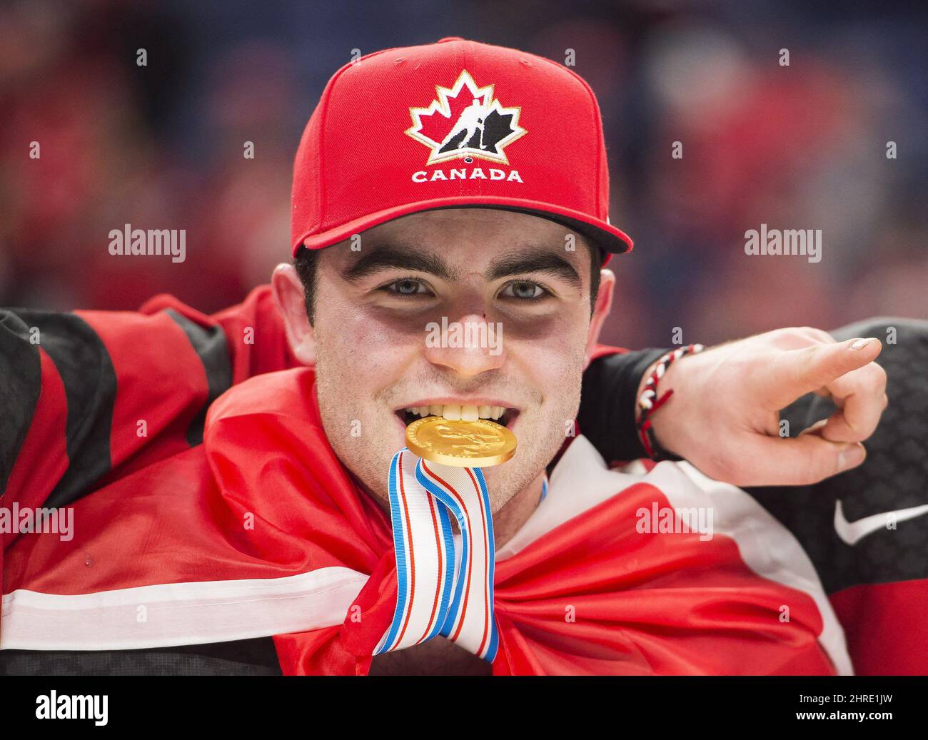 Canada forward Dillon DubÃ© (9) bites his gold medal after defeating Sweden in gold medal final