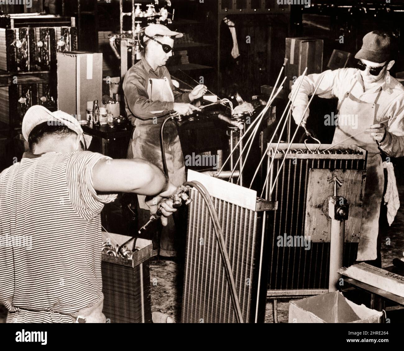 1960s THREE MEN WORKING WELDING AIR CONDITIONERS WESTINGHOUSE PLANT STAUNTON VIRGINIA USA - i776 LAN001 HARS PROTECTION INNOVATION LABOR OPPORTUNITY EMPLOYMENT MANUFACTURING OCCUPATIONS WELDING AIR CONDITIONERS EMPLOYEE MID-ADULT MID-ADULT MAN PRECISION YOUNG ADULT MAN BLACK AND WHITE CAUCASIAN ETHNICITY LABORING OLD FASHIONED Stock Photo
