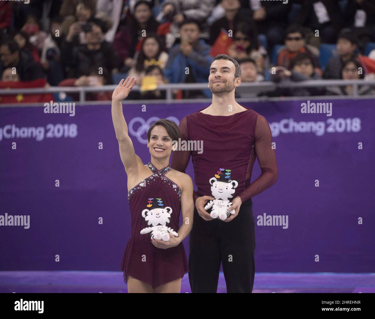 Canada's Meagan Duhamel and Eric Radford wave from the podium after