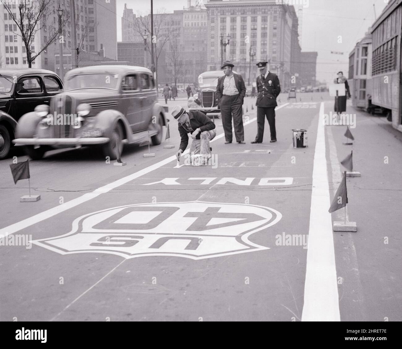 1930s WORKERS PAINTING ROUTE SIGN ON ROAD FOR TURN ONTO US ROUTE 40 A MAJOR TRANSCONTINENTAL ROUTE ST. LOUIS MISSOURI USA - q44629 CPC001 HARS VEHICLE TEAMWORK TURN HISTORY FEMALES UNITED STATES COPY SPACE HIGHWAY LADIES PERSONS UNITED STATES OF AMERICA AUTOMOBILE MALES ORDER OFFICER PAINTER TRANSPORTATION B&W NORTH AMERICA COP DIRECTIONS NORTH AMERICAN PROTECT LOUIS AND AUTOS MISSOURI DIRECTION LABOR EMPLOYMENT OCCUPATIONS ONTO UNIFORMS FREEWAY AUTOMOBILES CITIES ROUTE ST. VEHICLES EMPLOYEE OFFICERS POLICEMEN COOPERATION COPS MAJOR ROADS SOLUTIONS BADGE BADGES BLACK AND WHITE Stock Photo