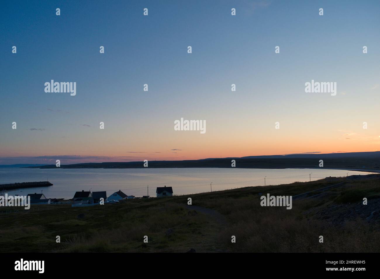 Beautiful shot of a fjord with houses in Ekkeroy, Varanger, Norway at sunset Stock Photo
