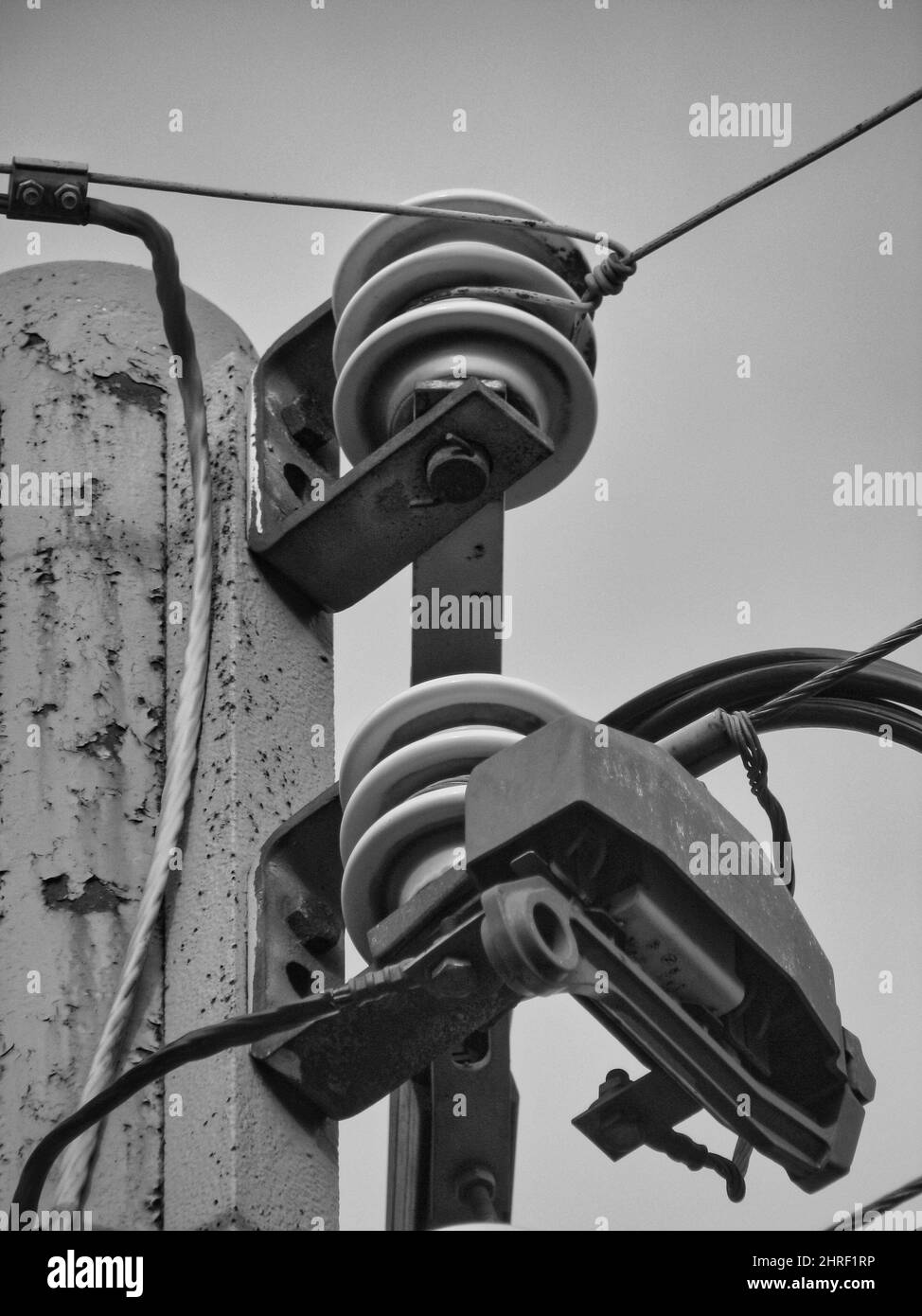 Metal power pole with old insulators as a detail photo in black and