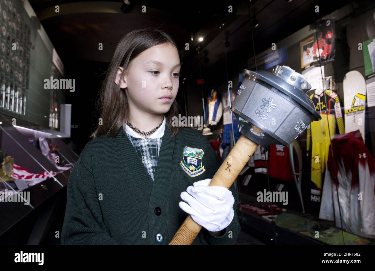 Calgary grade two student Emma Lee, is allowed to hold, with cotton gloves, a 1988 Calgary Winter Olypics torch from the Olympic Torch Run during her school tour at Canada's Sports Hall of Fame in Calgary, Alta. on Wednesday, April 11, 2018. THE CANADIAN PRESS/Larry MacDougal Stock Photo