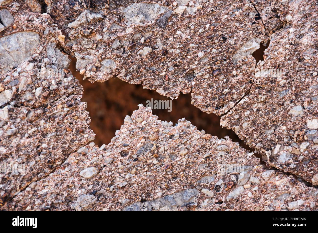 a natural crack in a thin limestone conglomerate rock layer Stock Photo