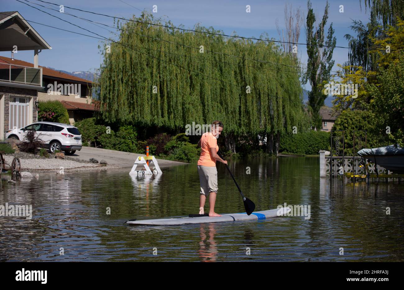 Trudy Johnston uses a stand up paddleboard to navigate the flooded