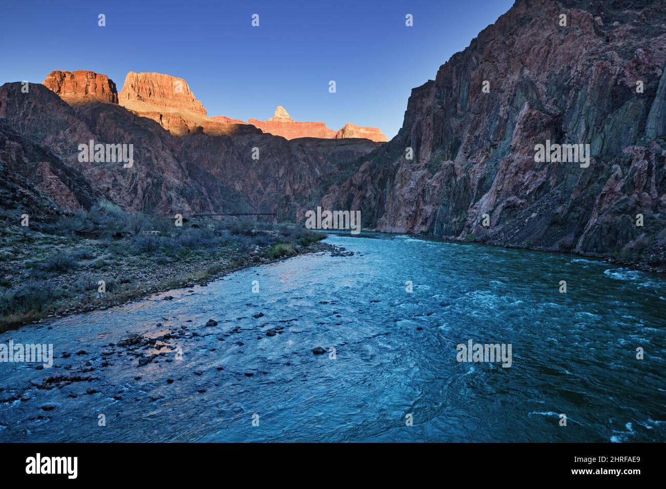 the Colorado River at the bottom of Grand Canyon National Park near sunset with light on Sumner Butte and Zoroaster Temple Stock Photo