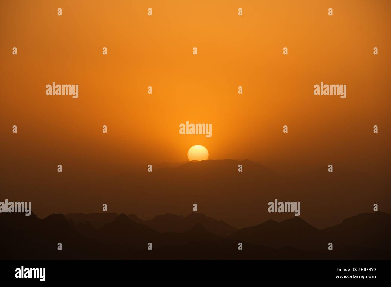 orange hazy sunset with copy space and mountain horizon ridges Stock Photo
