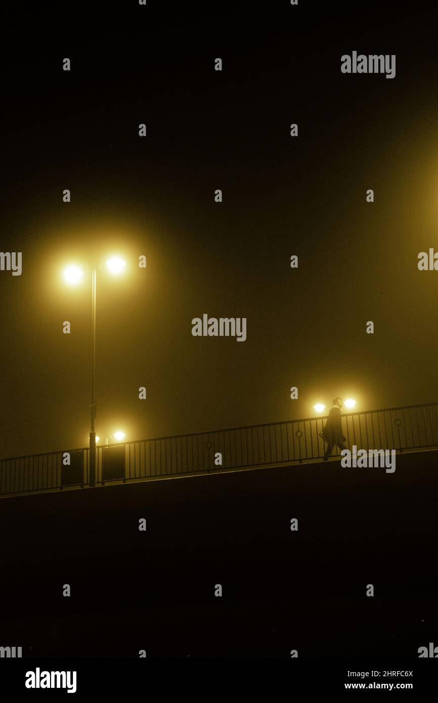 Silhouette of a man walking on the street at a foggy night Stock Photo ...