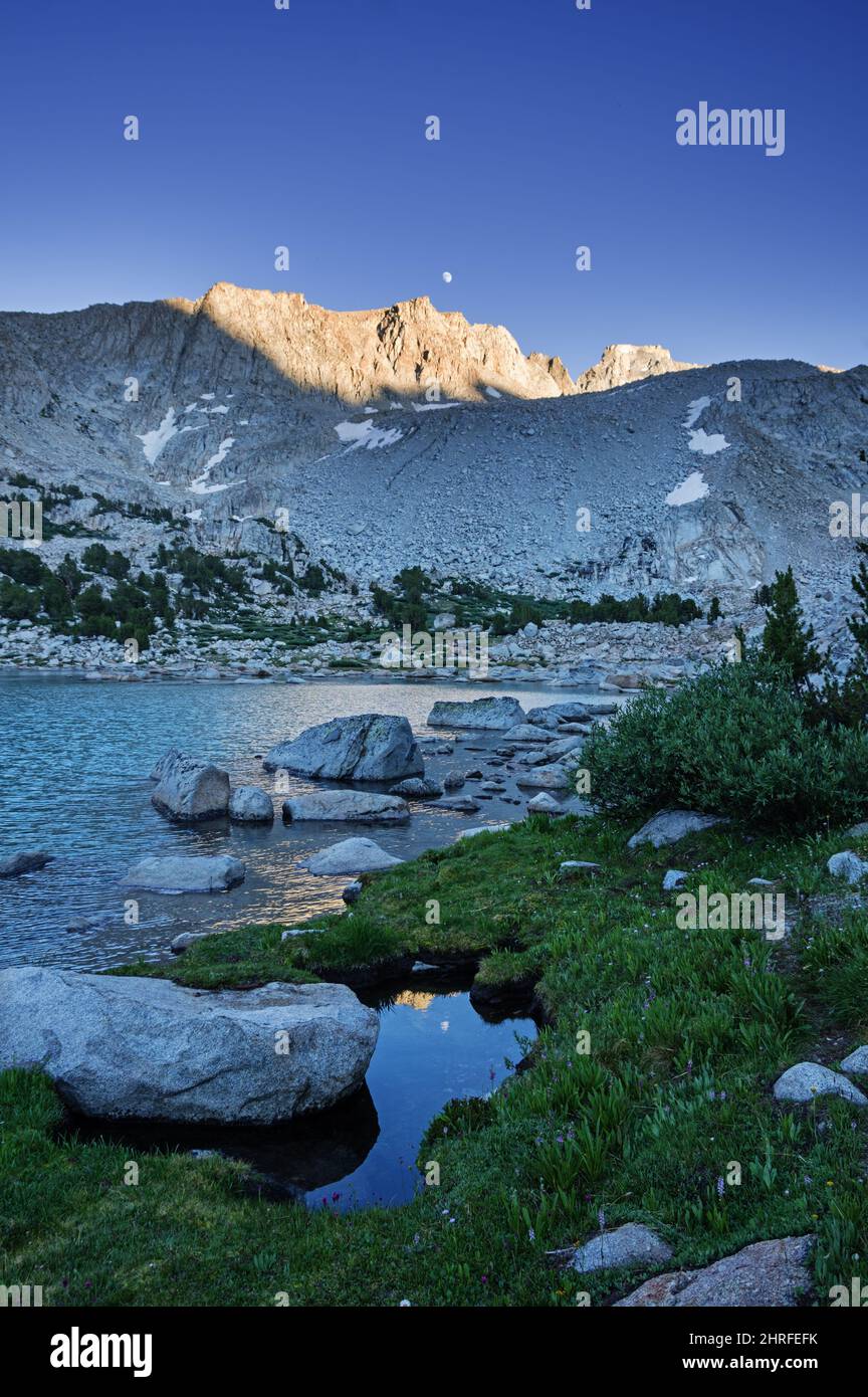 moon and cliffs reflected in Midnight Lake in the Sierra Nevada Mountains in California Stock Photo