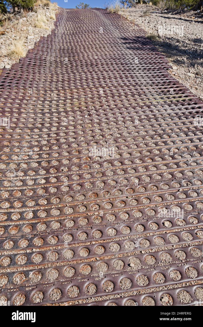 Marston mat on steep cinder roadway to prevent erosion and provide grip Stock Photo