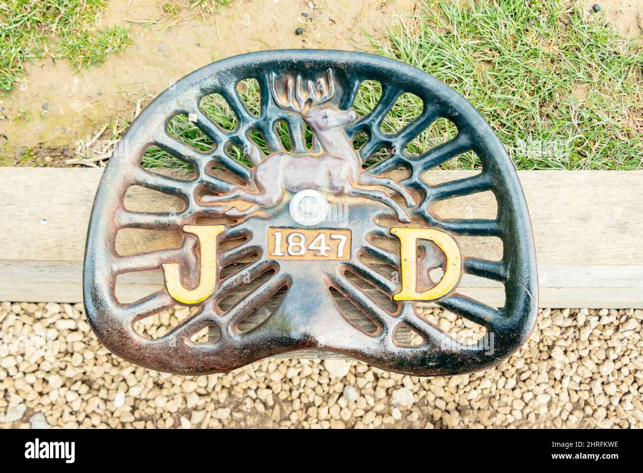 close up top view of cast metal John Deere tractor seat with deer logo