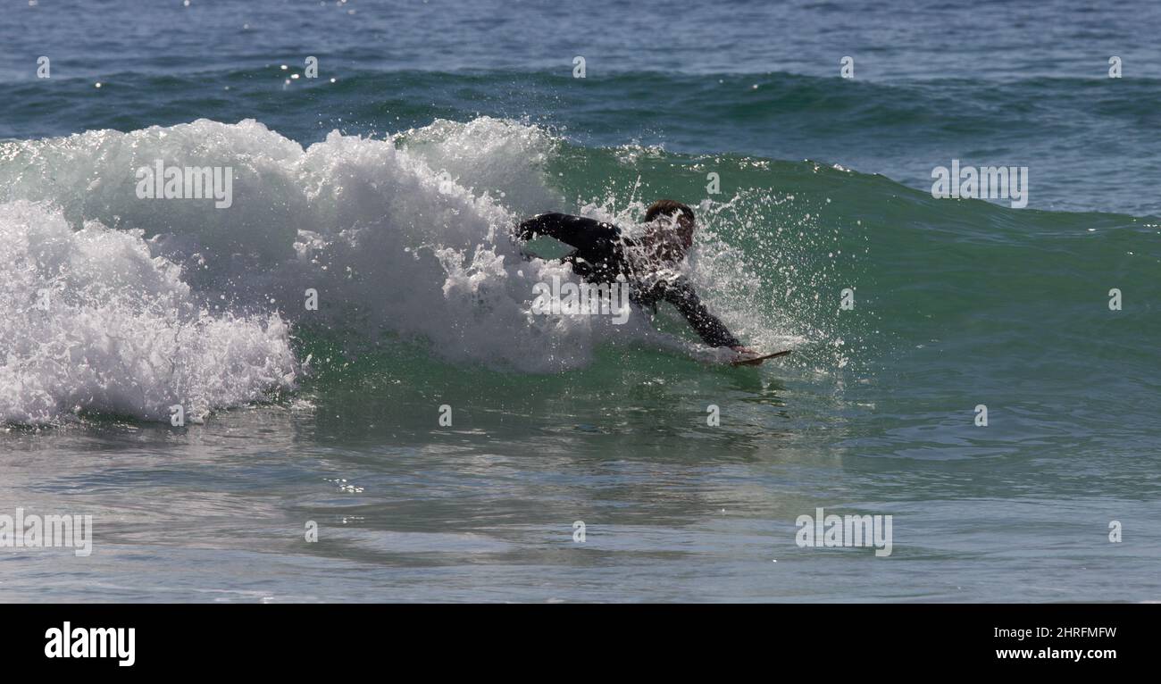 Body boarding or short boarding, riding a wave; Kynance Cove, Cornwall Stock Photo